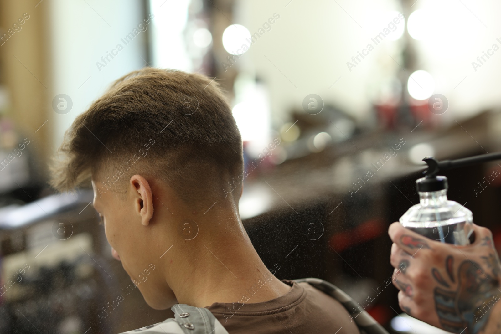 Professional barber working with client in barbershop, closeup Photo of Professional barber working with client in barbershop, closeup