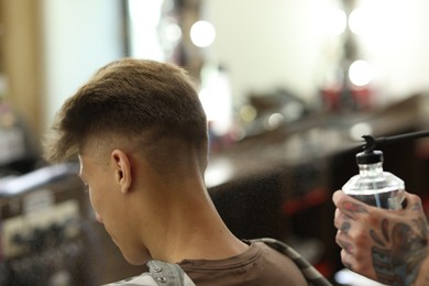 Photo of Professional barber working with client in barbershop, closeup