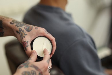 Photo of Professional barber working with client in barbershop, closeup