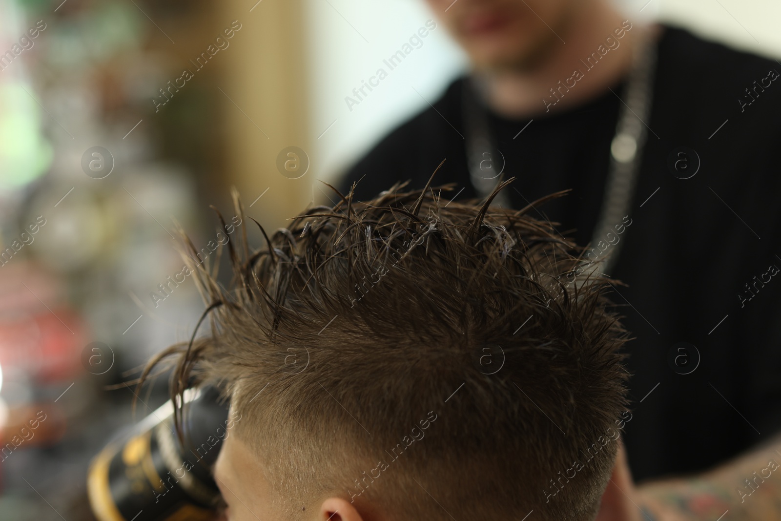 Professional barber working with client in barbershop, closeup Photo of Professional barber working with client in barbershop, closeup