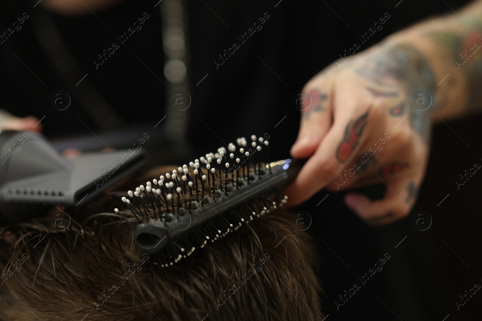 Professional barber blow drying client's hair in barbershop, closeup Photo of Professional barber blow drying client's hair in barbershop, closeup