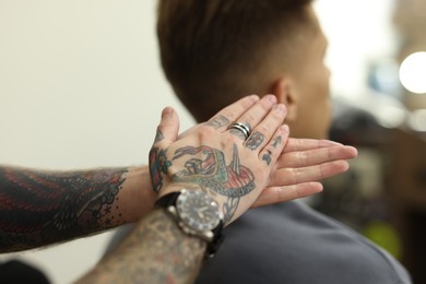 Photo of Professional barber working with client in barbershop, closeup