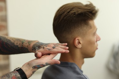 Photo of Professional barber working with client in barbershop, closeup