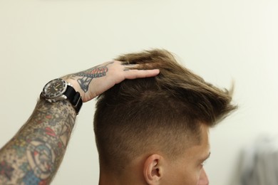 Photo of Professional barber working with client in barbershop, closeup