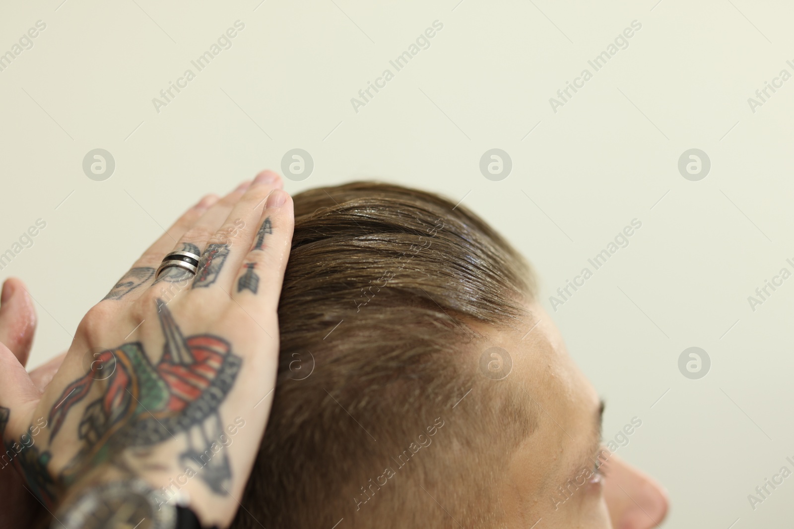 Professional barber working with client in barbershop, closeup Photo of Professional barber working with client in barbershop, closeup