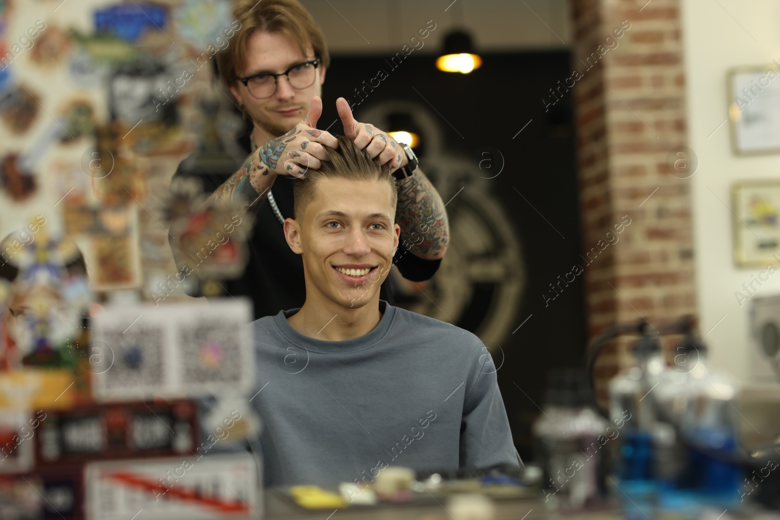 Professional barber working with client in barbershop Photo of Professional barber working with client in barbershop