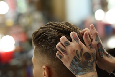 Photo of Professional barber working with client in barbershop, closeup