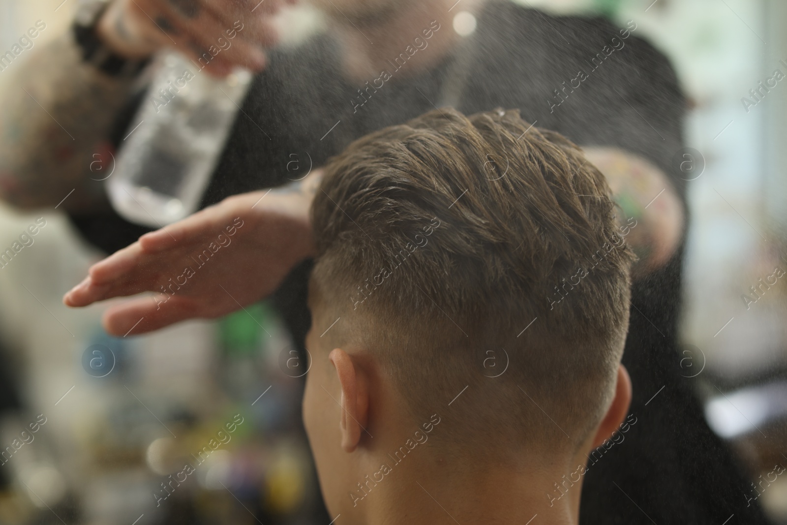 Professional barber working with client in barbershop, closeup Photo of Professional barber working with client in barbershop, closeup