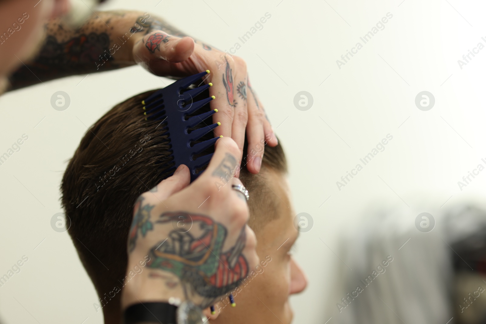Professional barber working with client in barbershop, closeup. Space for text Photo of Professional barber working with client in barbershop, closeup. Space for text