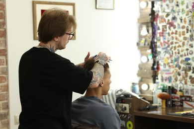 Photo of Professional barber working with client in barbershop