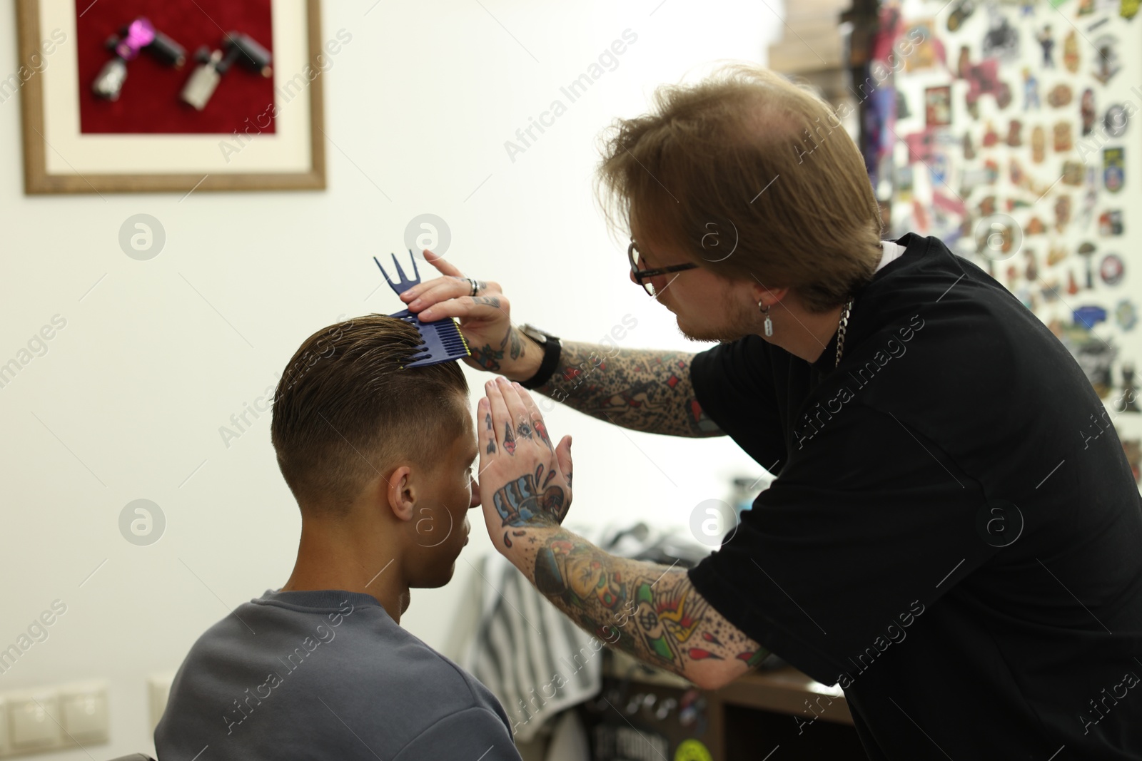 Professional barber working with client in barbershop Photo of Professional barber working with client in barbershop