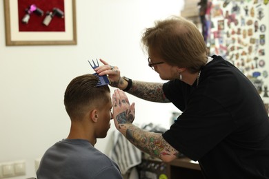 Photo of Professional barber working with client in barbershop