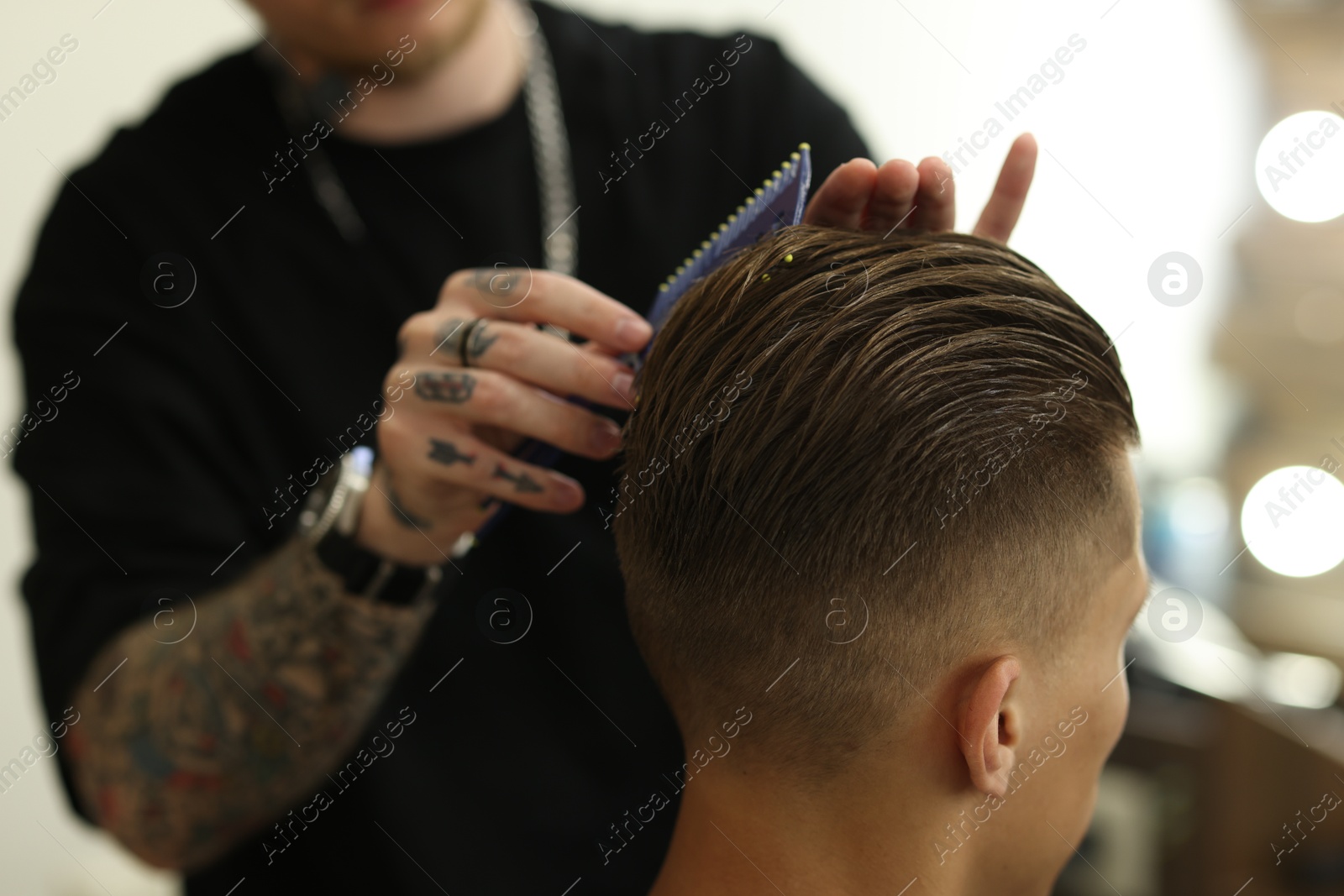 Professional barber making stylish haircut in barbershop, closeup Photo of Professional barber making stylish haircut in barbershop, closeup