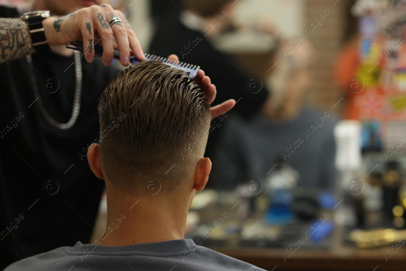 Professional barber making stylish haircut in barbershop, closeup. Space for text Photo of Professional barber making stylish haircut in barbershop, closeup. Space for text