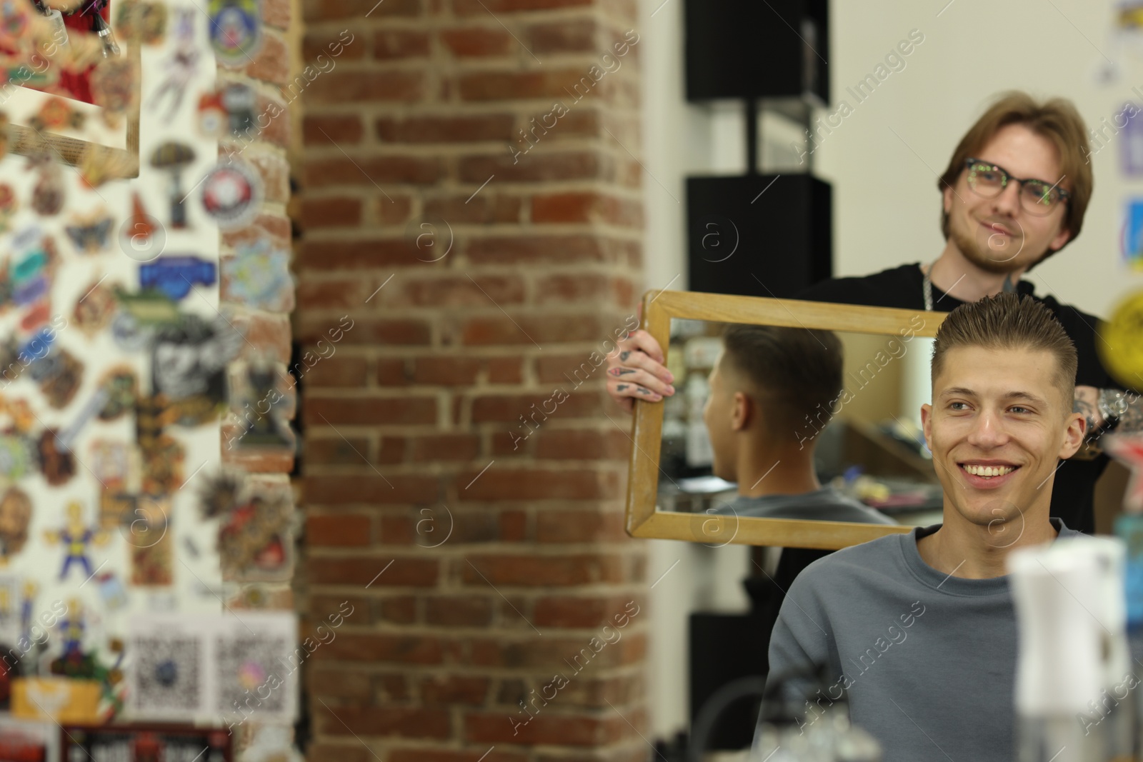 Professional barber working with client in barbershop, space for text Photo of Professional barber working with client in barbershop, space for text