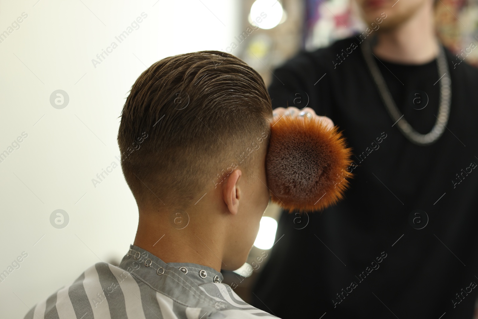 Professional barber working with client in barbershop, closeup Photo of Professional barber working with client in barbershop, closeup