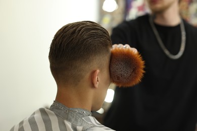 Photo of Professional barber working with client in barbershop, closeup