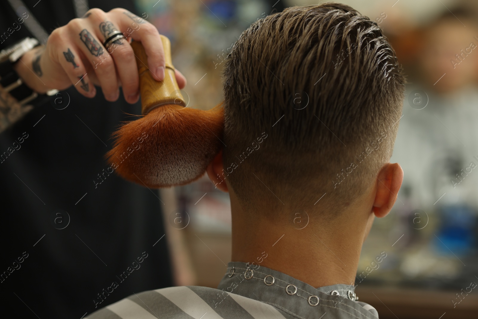 Professional barber working with client in barbershop, closeup Photo of Professional barber working with client in barbershop, closeup