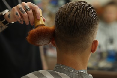Photo of Professional barber working with client in barbershop, closeup