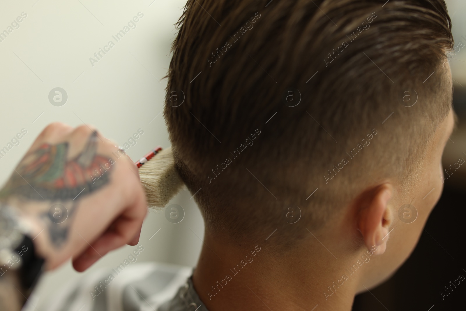 Professional barber working with client in barbershop, closeup Photo of Professional barber working with client in barbershop, closeup