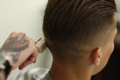 Photo of Professional barber working with client in barbershop, closeup