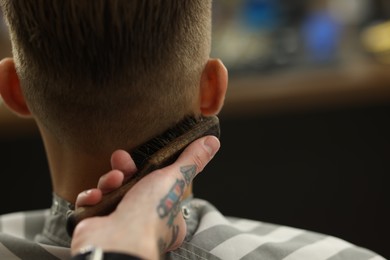 Photo of Professional barber working with client in barbershop, closeup. Space for text