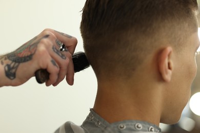 Photo of Professional barber working with client in barbershop, closeup