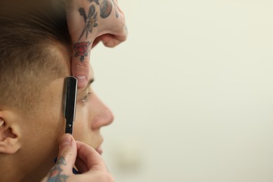 Photo of Professional barber working with client in barbershop, closeup. Space for text