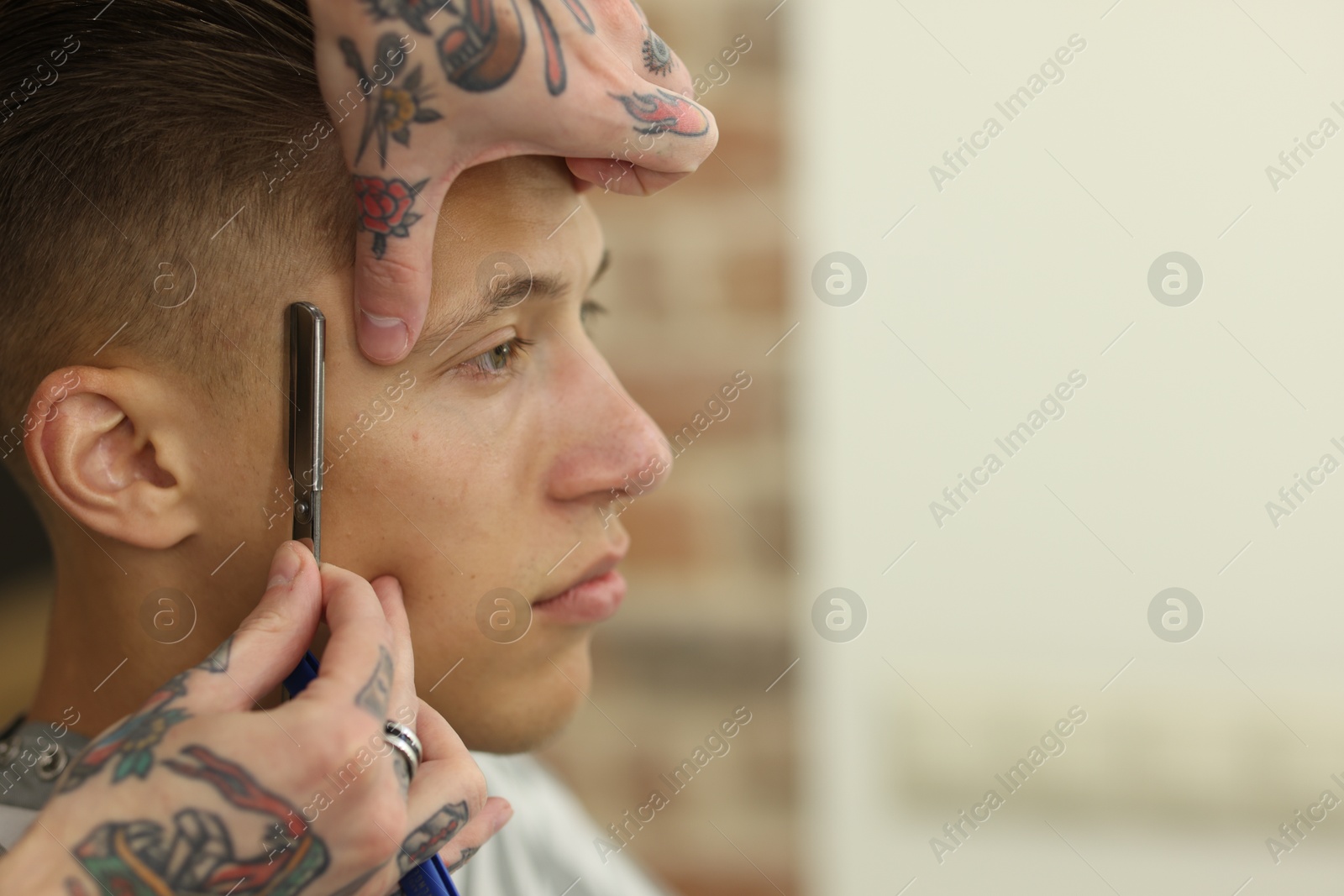 Professional barber working with client in barbershop, closeup. Space for text Photo of Professional barber working with client in barbershop, closeup. Space for text