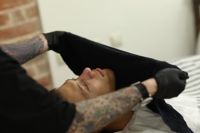 Photo of Professional barber working with client in barbershop, closeup