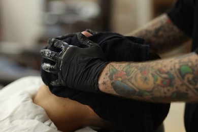 Photo of Professional barber working with client in barbershop, closeup