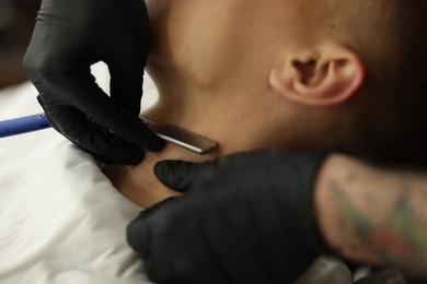 Photo of Professional barber working with client in barbershop, closeup