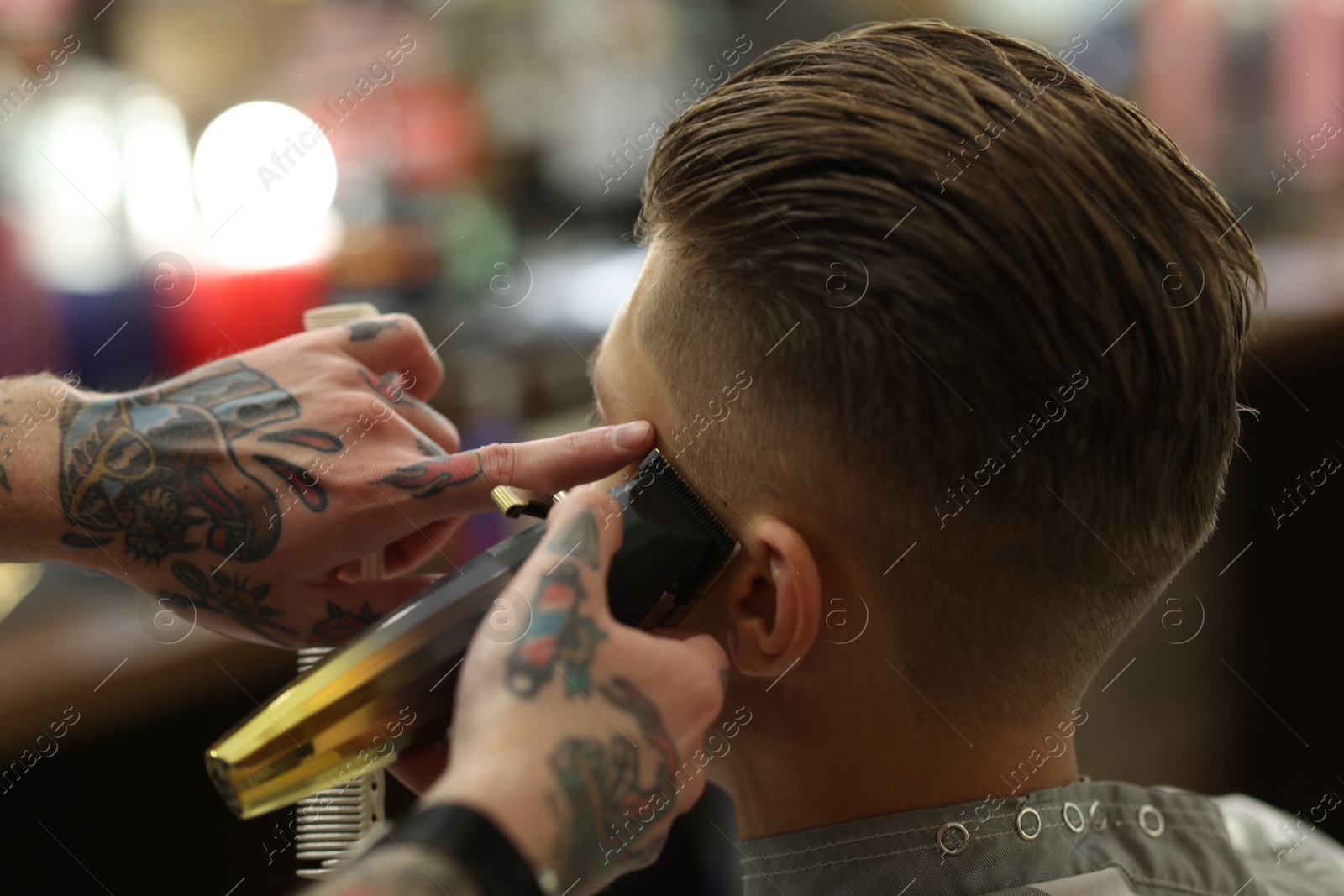 Professional barber working with client in barbershop, closeup Photo of Professional barber working with client in barbershop, closeup