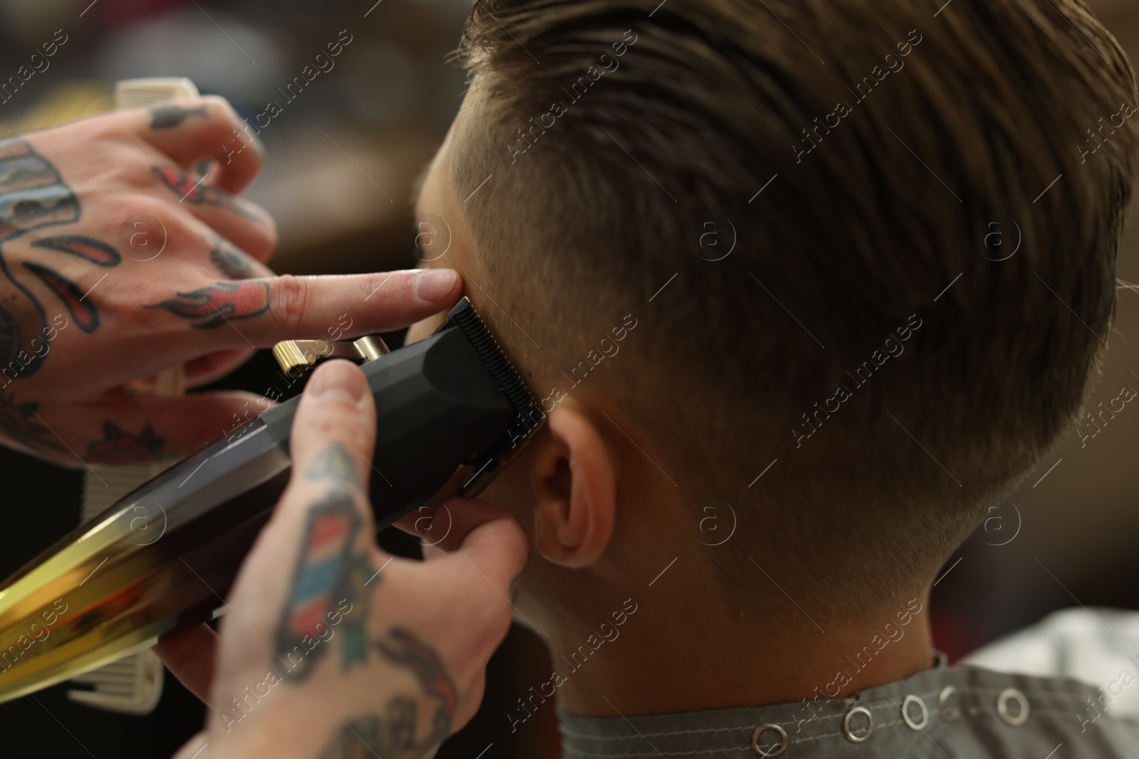 Professional barber working with client in barbershop, closeup Photo of Professional barber working with client in barbershop, closeup