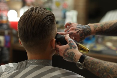 Photo of Professional barber working with client in barbershop, closeup