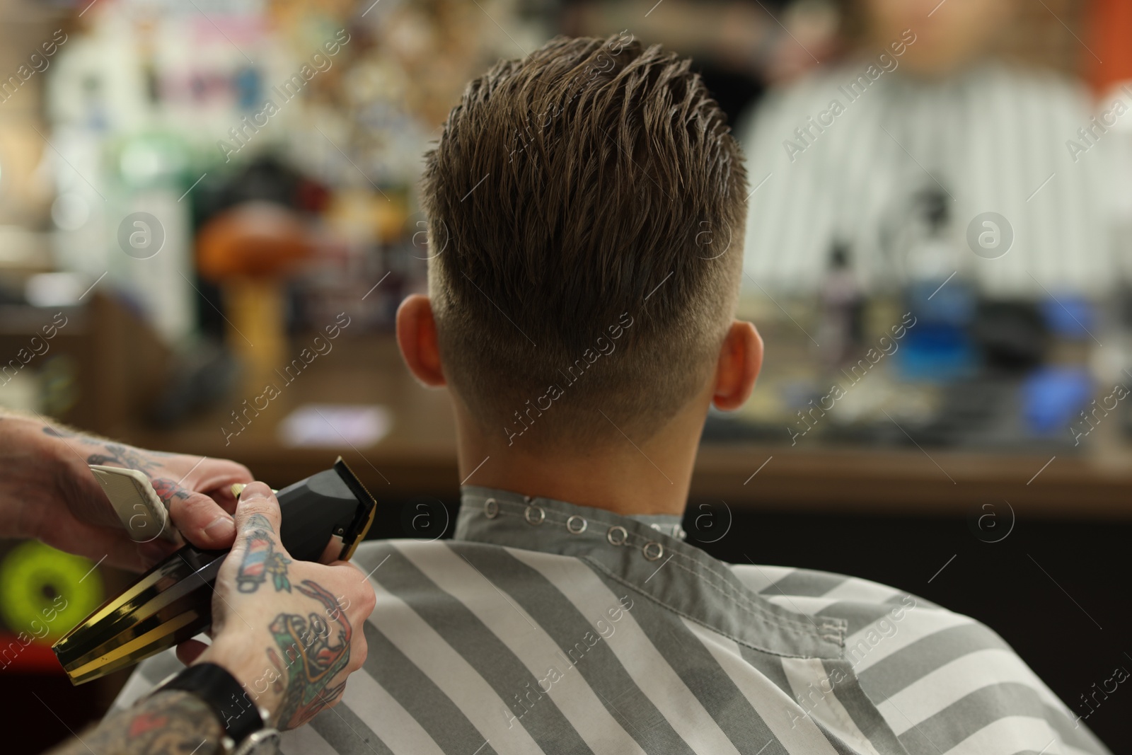 Professional barber working with client in barbershop, closeup Photo of Professional barber working with client in barbershop, closeup