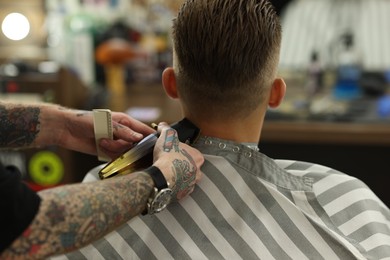 Photo of Professional barber working with client in barbershop, closeup