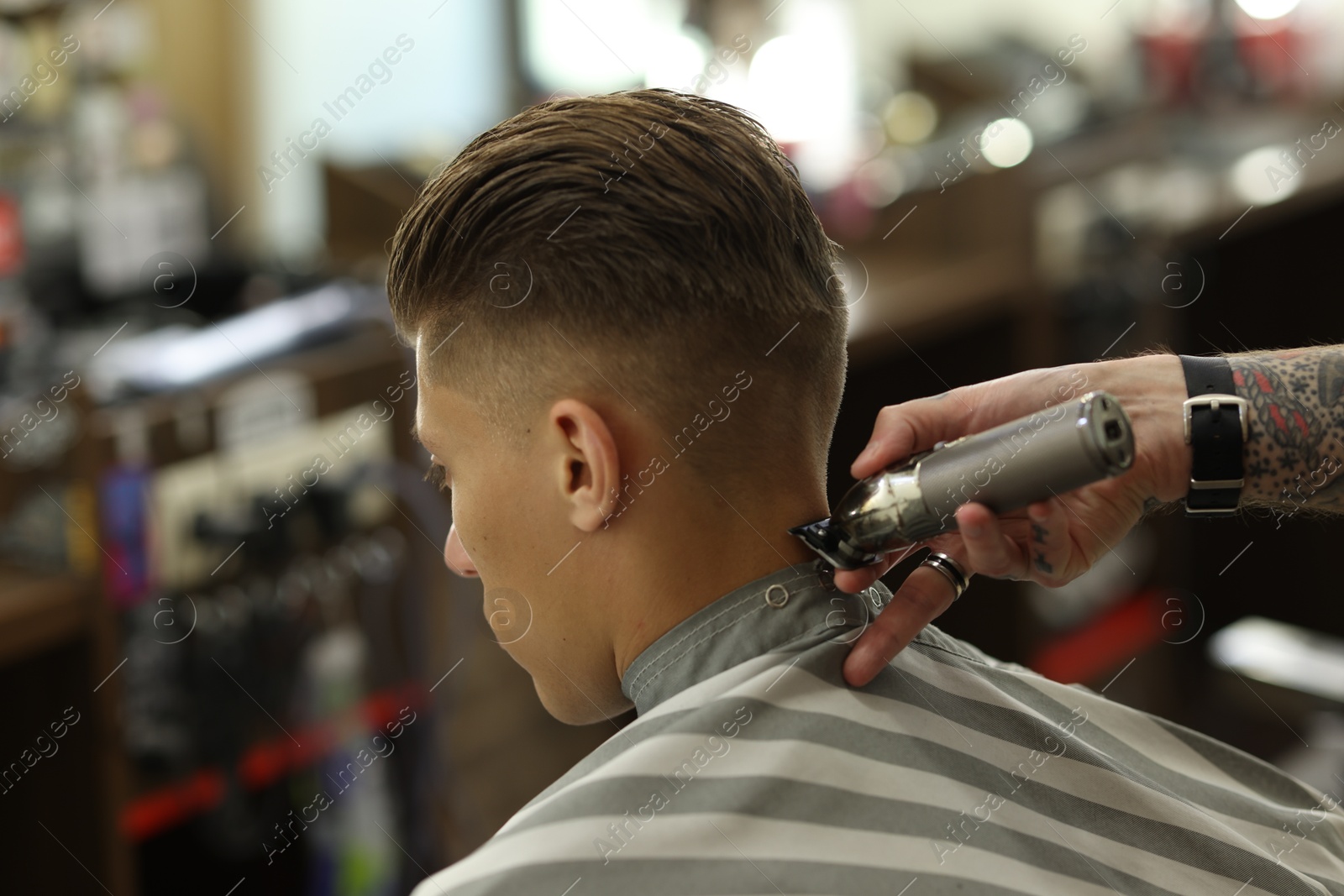 Professional barber working with client in barbershop, closeup Photo of Professional barber working with client in barbershop, closeup