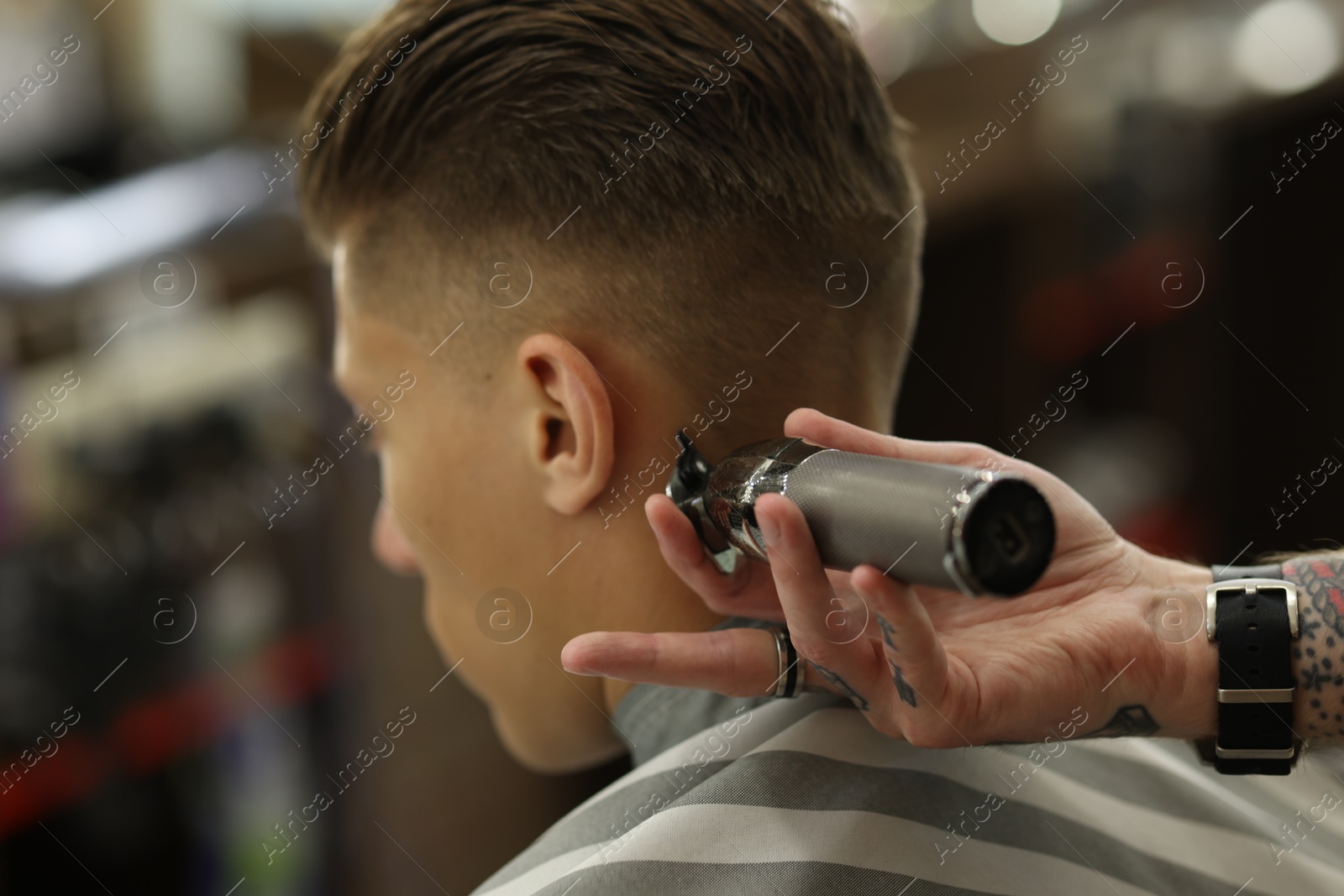 Professional barber working with client in barbershop, closeup Photo of Professional barber working with client in barbershop, closeup