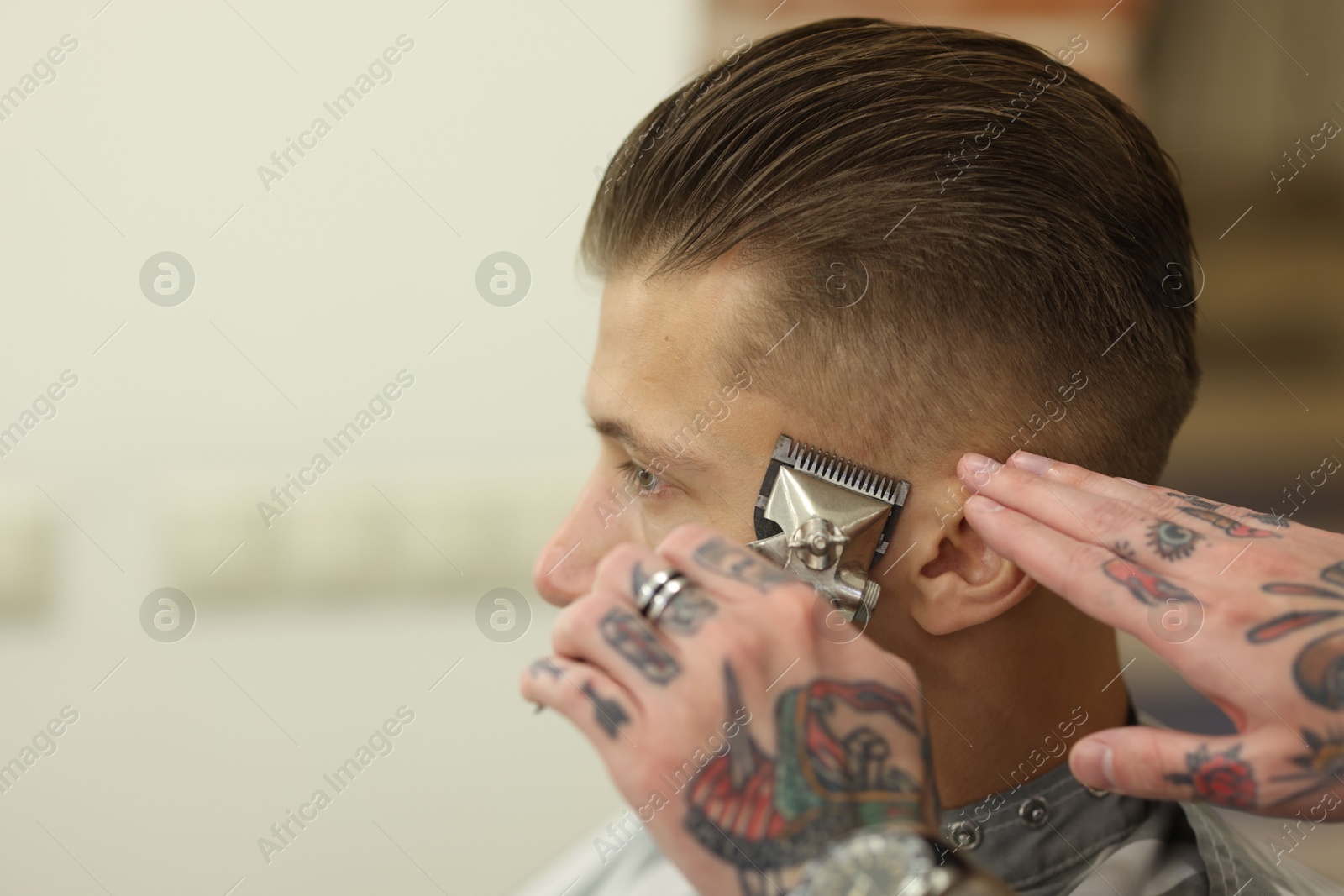 Professional barber working with client in barbershop, closeup. Space for text Photo of Professional barber working with client in barbershop, closeup. Space for text