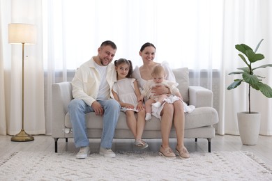 Photo of Happy parents and their kids together on sofa at home