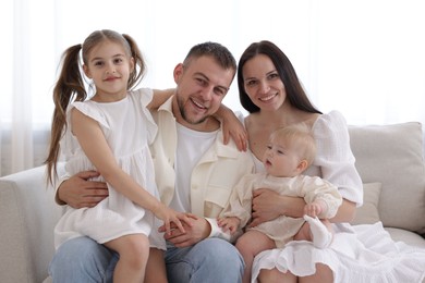 Photo of Happy parents and their kids together on sofa at home