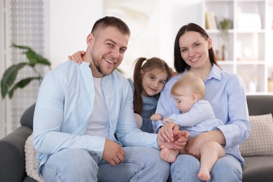 Photo of Happy parents and their kids together on sofa at home