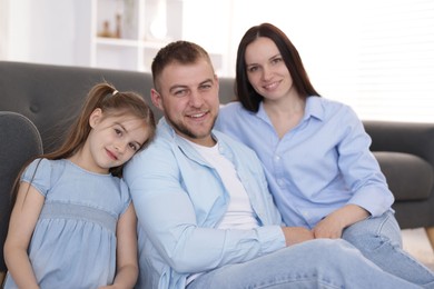 Photo of Happy parents and their daughter together on sofa at home