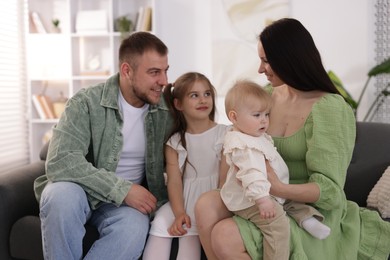 Photo of Happy parents and their kids together on sofa at home