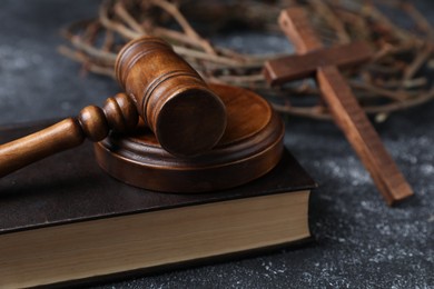Photo of Crown of thorns, judge's gavel, Bible and wooden cross on dark textured background, closeup