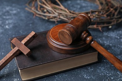 Photo of Crown of thorns, judge's gavel, Bible and wooden cross on dark textured background, closeup