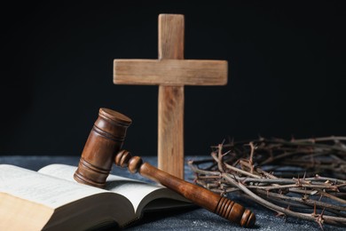 Photo of Crown of thorns, judge's gavel, Bible and wooden cross on dark textured background