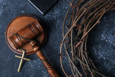Photo of Crown of thorns and judge's gavel with cross on dark textured background, closeup