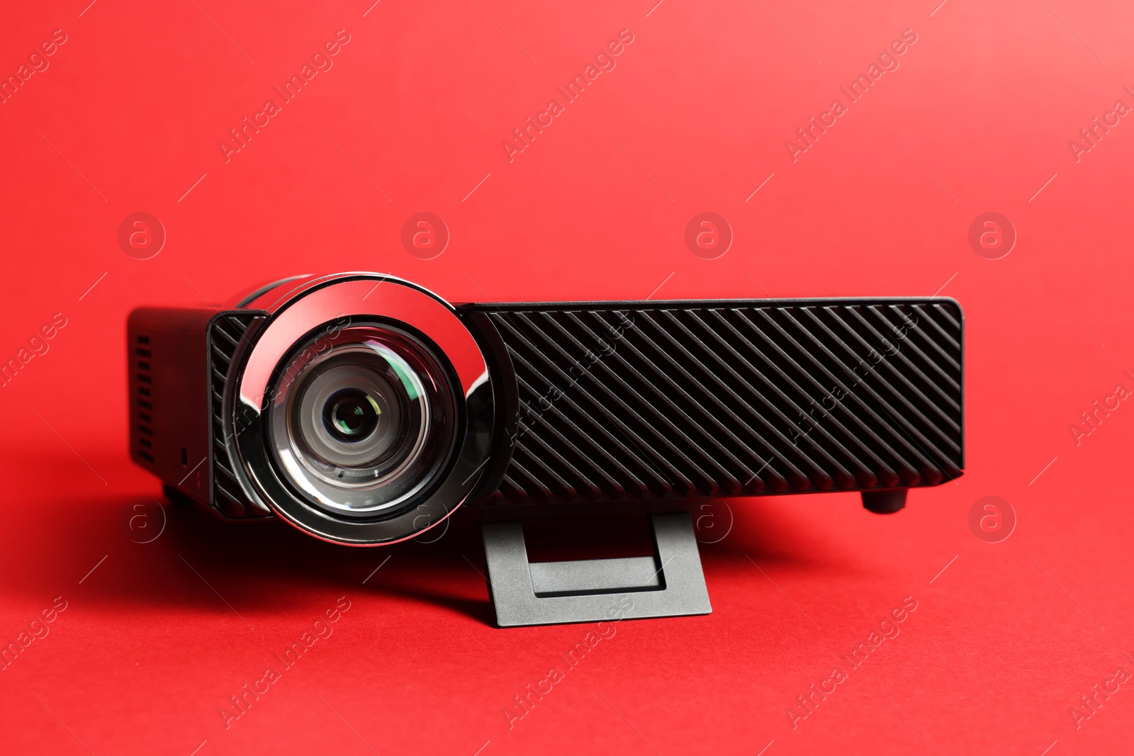 Modern video projector on red background, closeup Photo of Modern video projector on red background, closeup